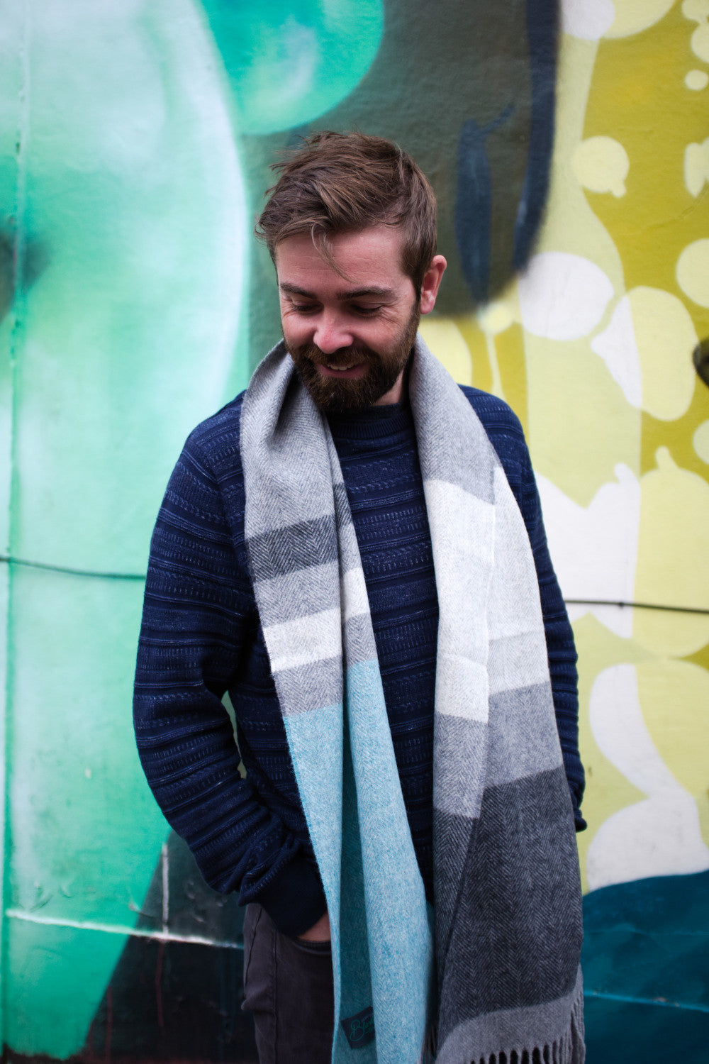 A man wearing a blue and grey lambswool scarf by The British Blanket Company.