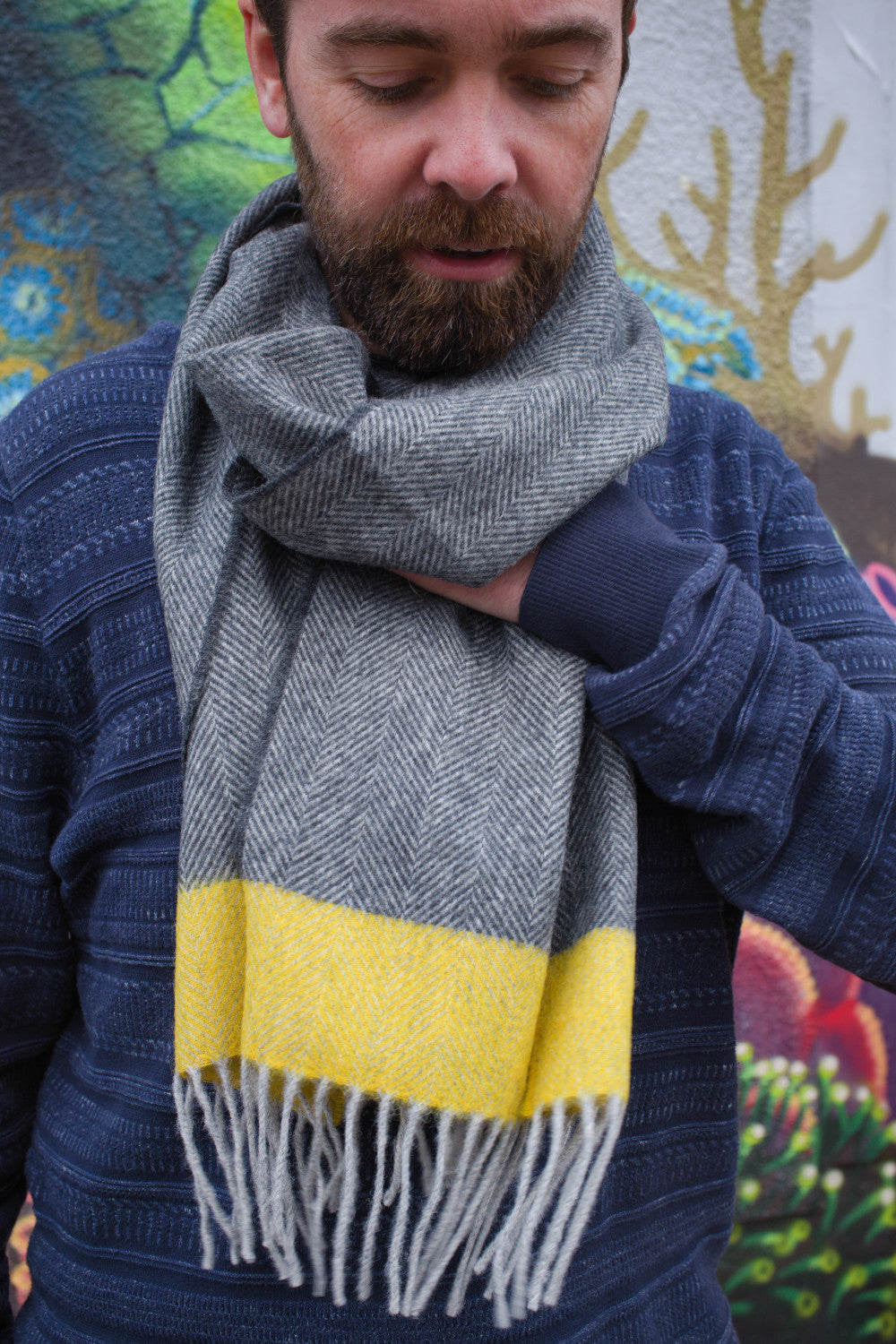 A man wearing a grey and yellow lambswool scarf around his neck