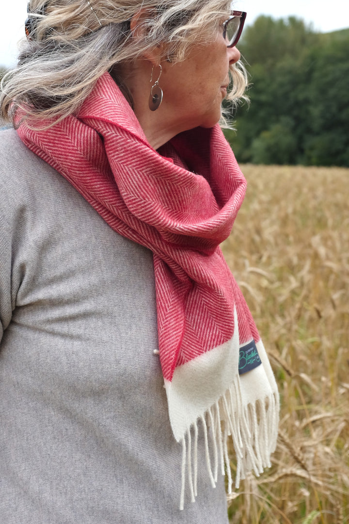 Side profile of a woman wearing a red herringbone lambswool scarf
