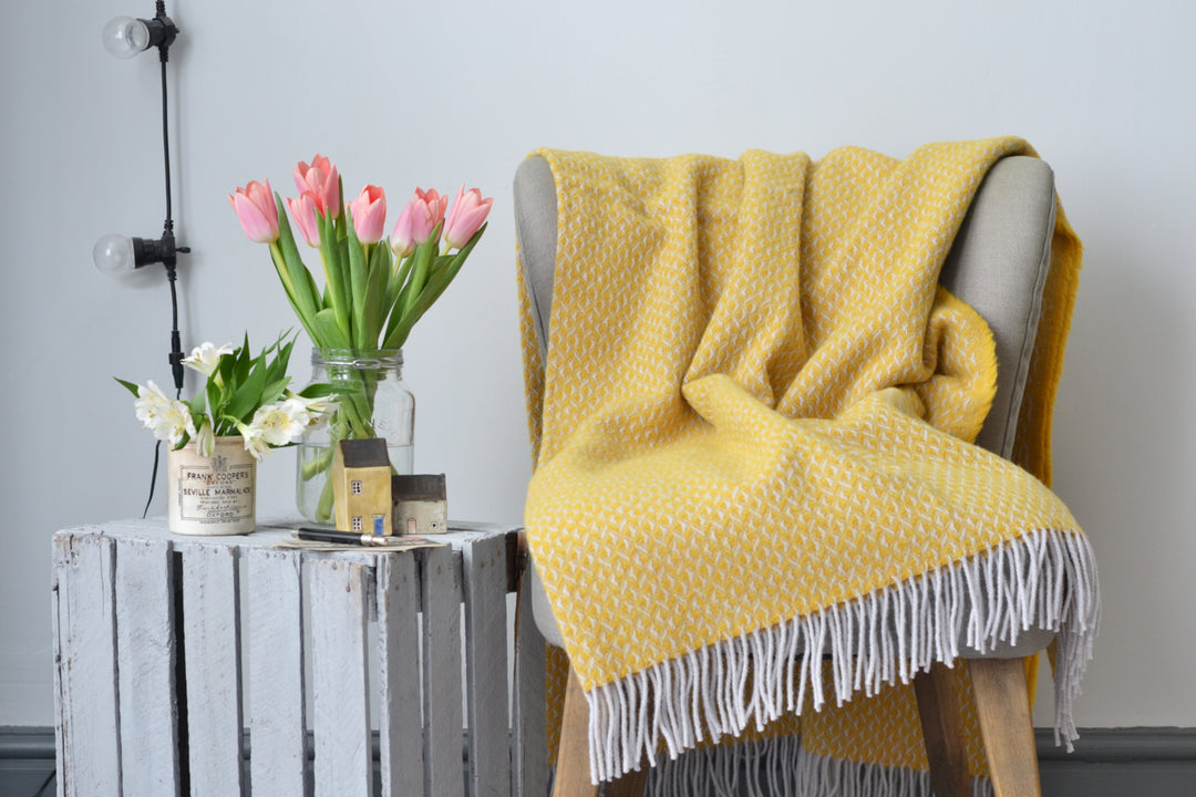 Large yellow diamond wool blanket draped over a lounge chair
