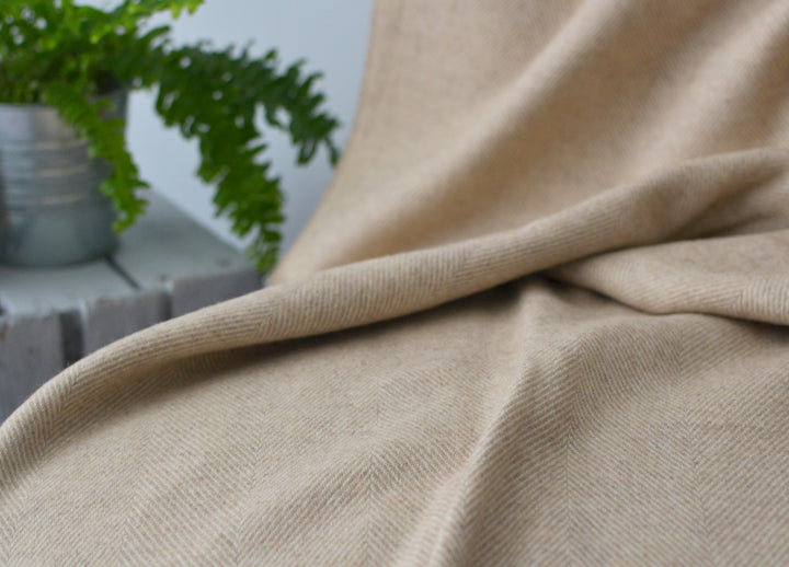 Closeup of a beige herringbone wool blanket.
