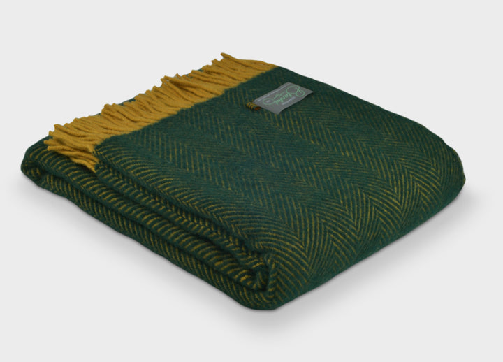 Folded green and yellow herringbone wool throw by The British Blanket Company