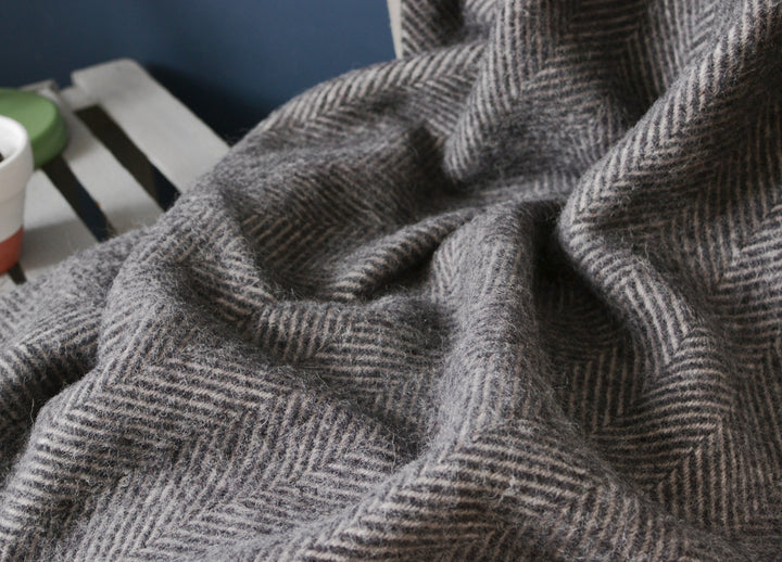 Closeup of a grey herringbone wool throw by the British Blanket Company.