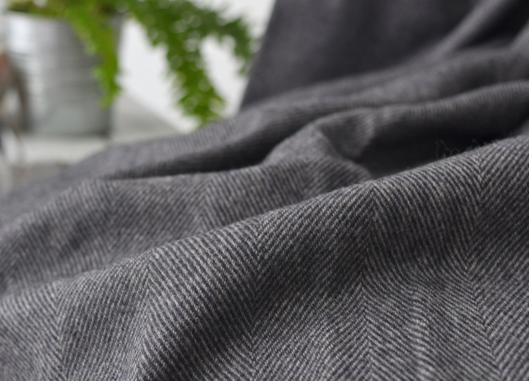 Closeup of grey merino herringbone wool throw by The British Blanket Company.