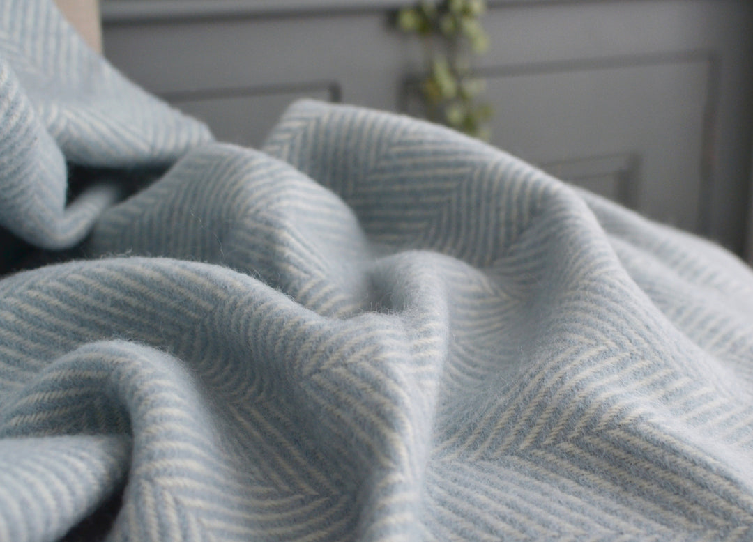 Closeup of light blue herringbone wool throw by The British Blanket Company.