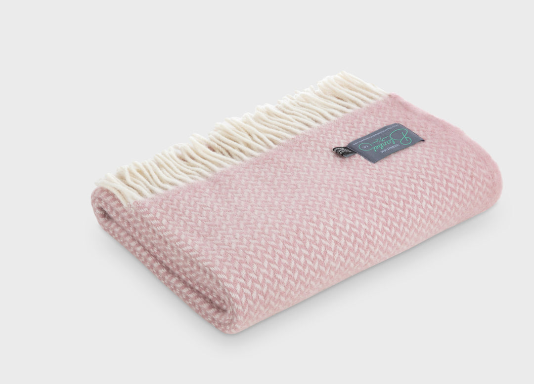 Folded pink herringbone wool throw by The British Blanket Company.