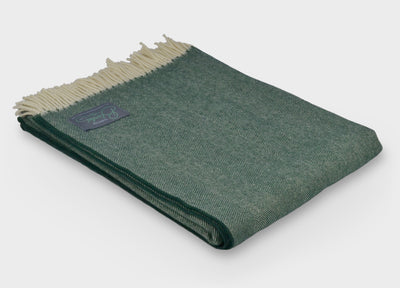 Folded green herringbone wool throw by The British Blanket Company.