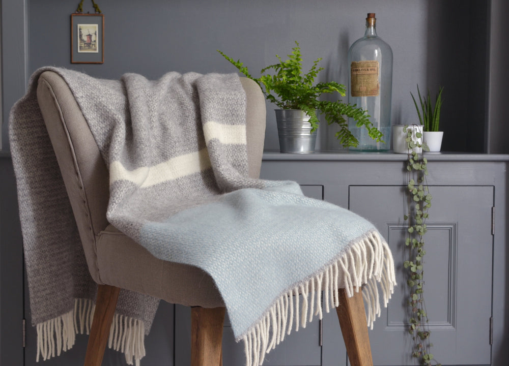 Grey and blue wool blanket draped over a lounge chair.