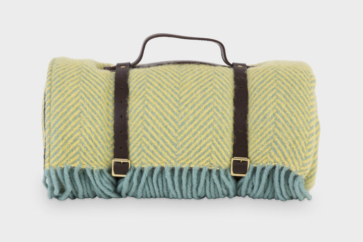 Yellow wool picnic blanket rolled up with leather straps
