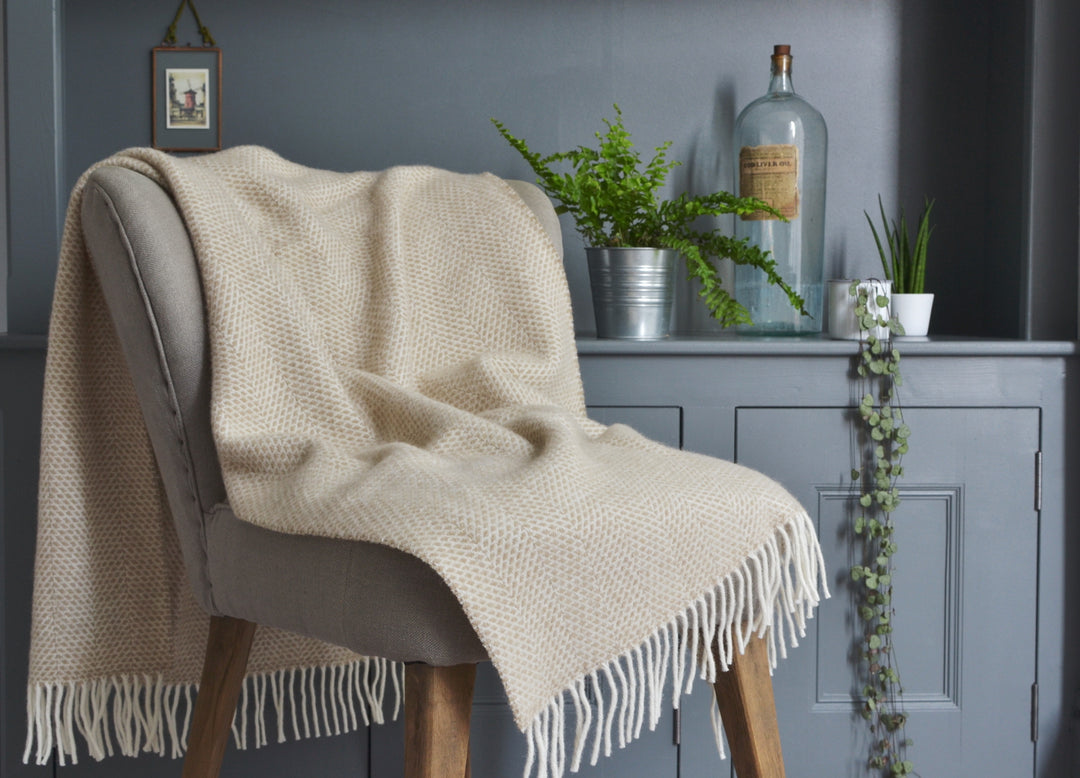 Beige beehive wool blanket draped over a lounge chair