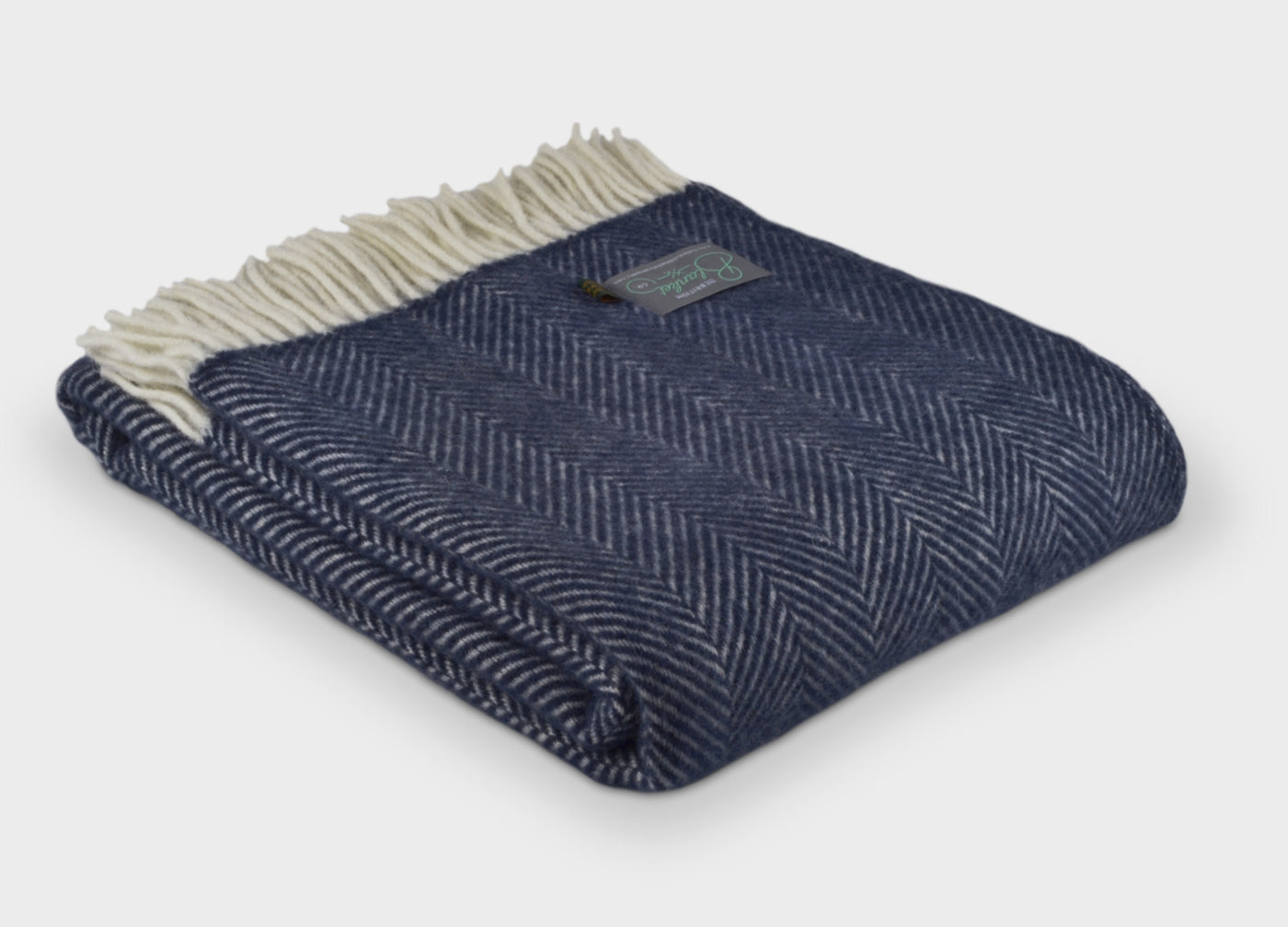 Folded large blue herringbone wool throw by The British Blanket Company
