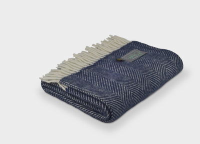 Folded navy blue herringbone wool throw by The British Blanket Company