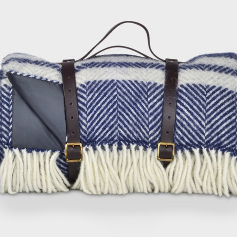 Blue and grey wool picnic rug by The British Blanket Company rolled up with leather straps