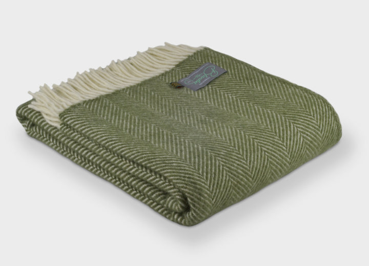 Folded large green herringbone wool throw by The British Blanket Company