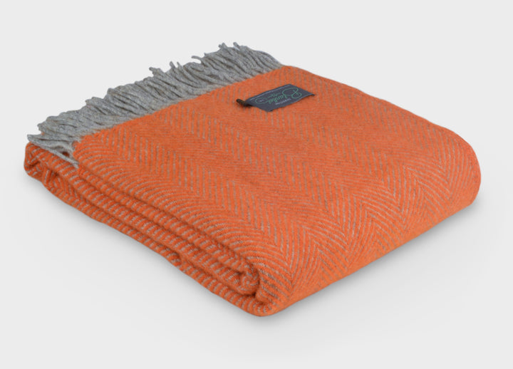 Folded large orange and grey herringbone wool throw by The British Blanket Company