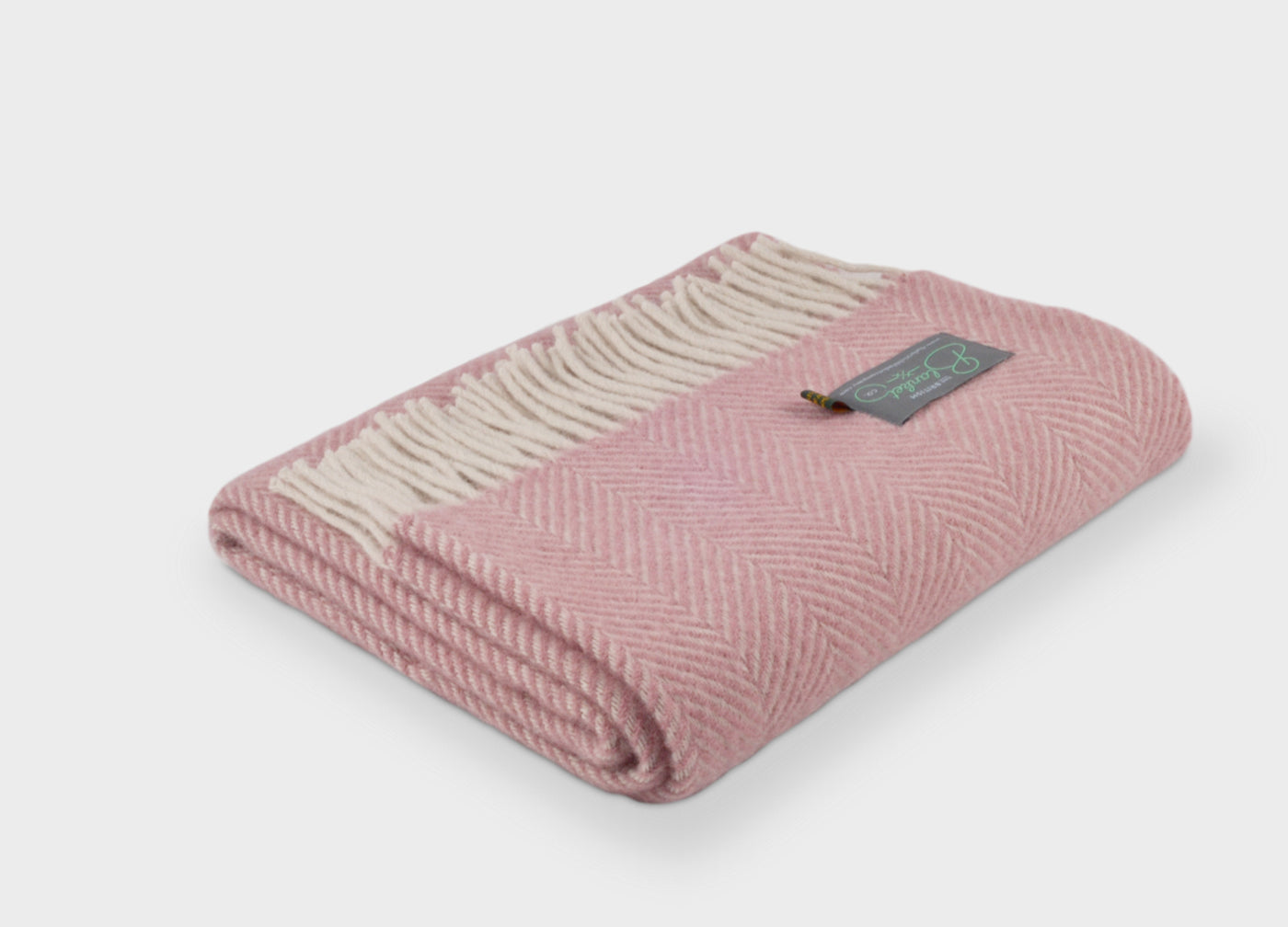 Folded pink herringbone wool throw by The British Blanket Company.