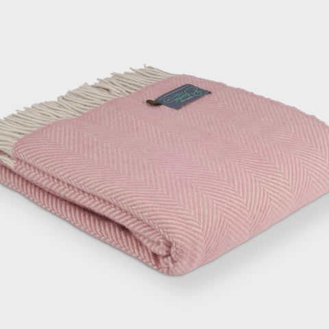Large folded pink herringbone wool throw by The British Blanket Company.