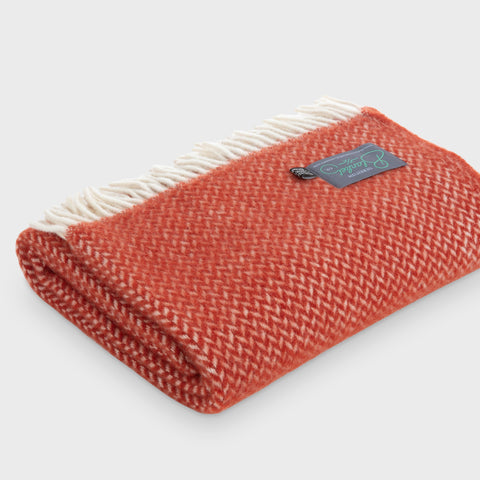 Folded red herringbone wool throw by The British Blanket Company