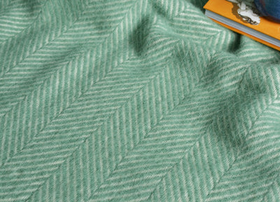 Closeup of a sea green herringbone wool throw