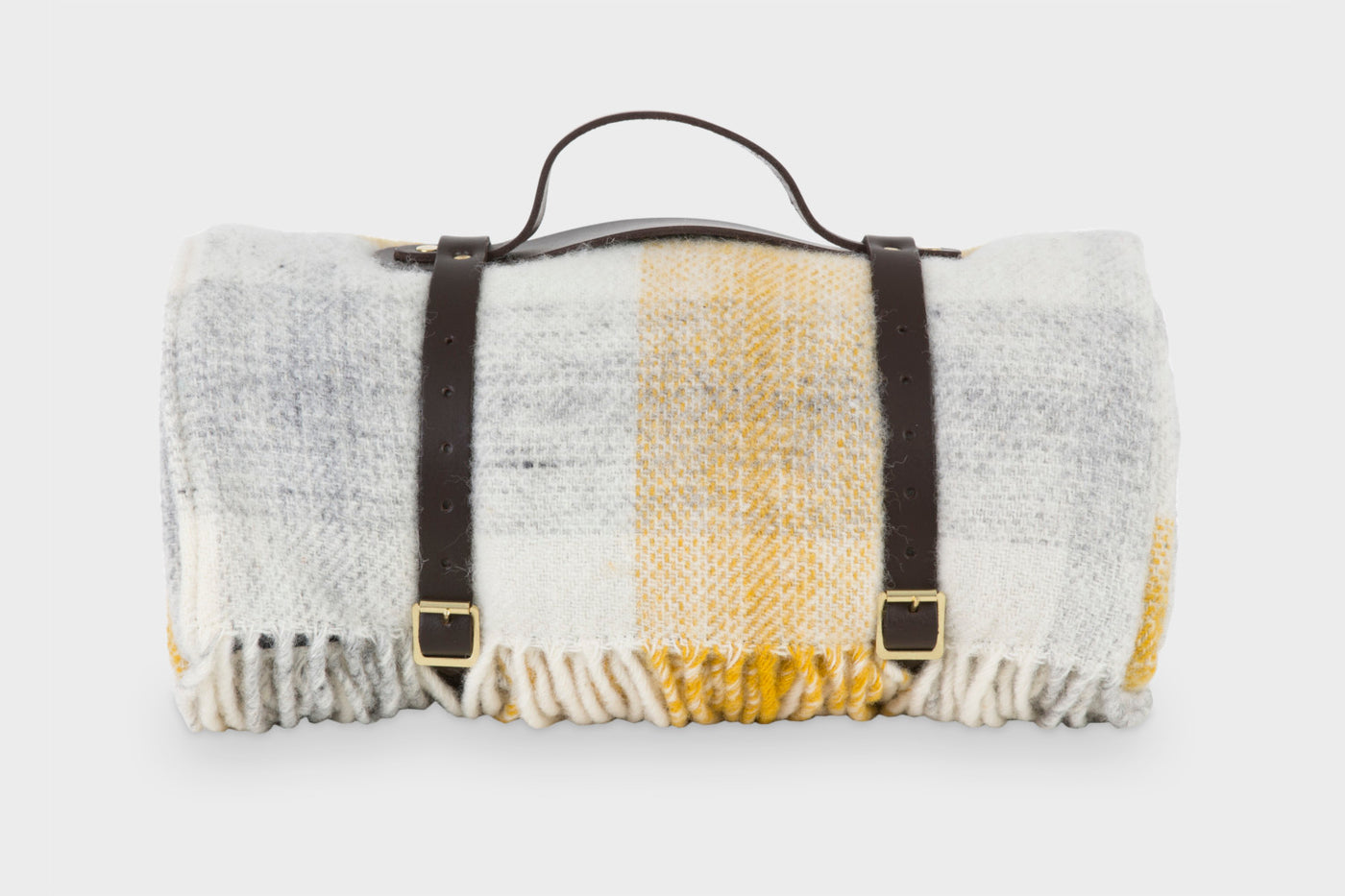 Yellow check wool picnic rug by The British Blanket Company rolled up with leather straps